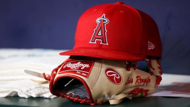 An Angels hat and glove for Luis Rengifo sit on a dugout before a game.